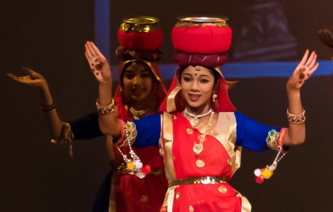 Girl balancing a pot on her head.