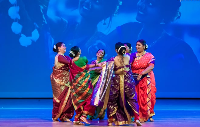 Women holding hands and dancing in a circle.