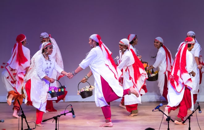 Girls carrying baskets of flowers and dancing.