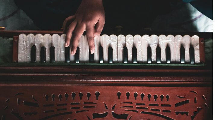 A person playing the Harmonium used in Bidesia folk dance performances.