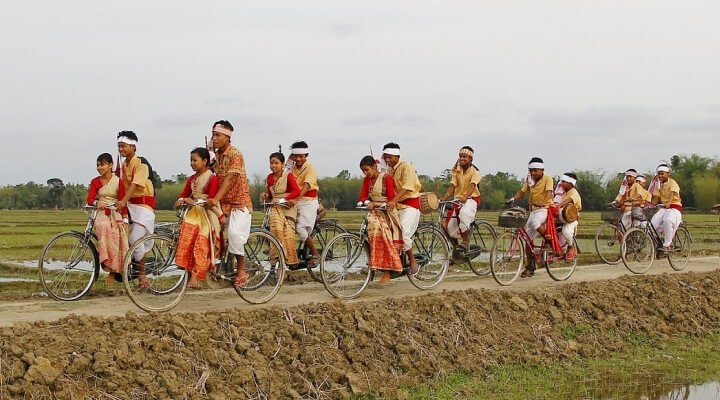 Dance performers riding on bicycles to a show to perform.