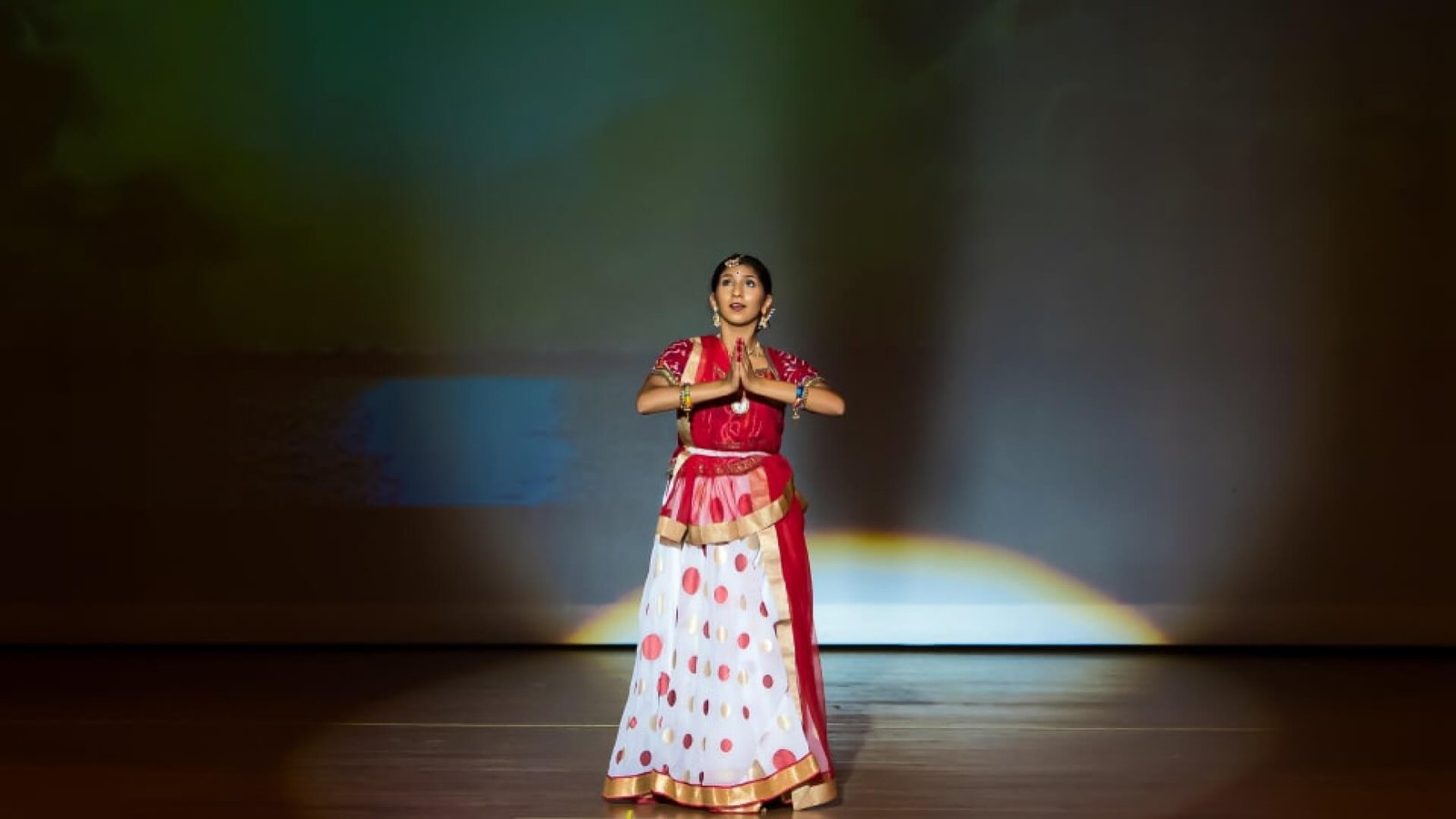 A student lost in trance while showing namaste with her hands.
