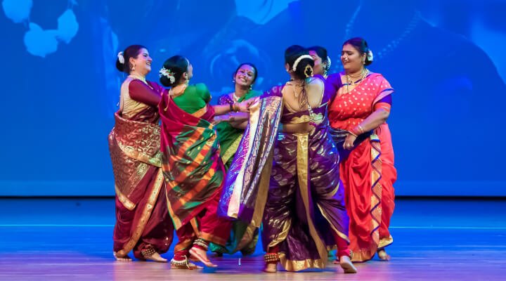 NSDA dances in close formation performing the Fugdi dance on stage.