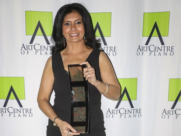 Vandita Parikh holding an award at the ArtCenter of Plano.