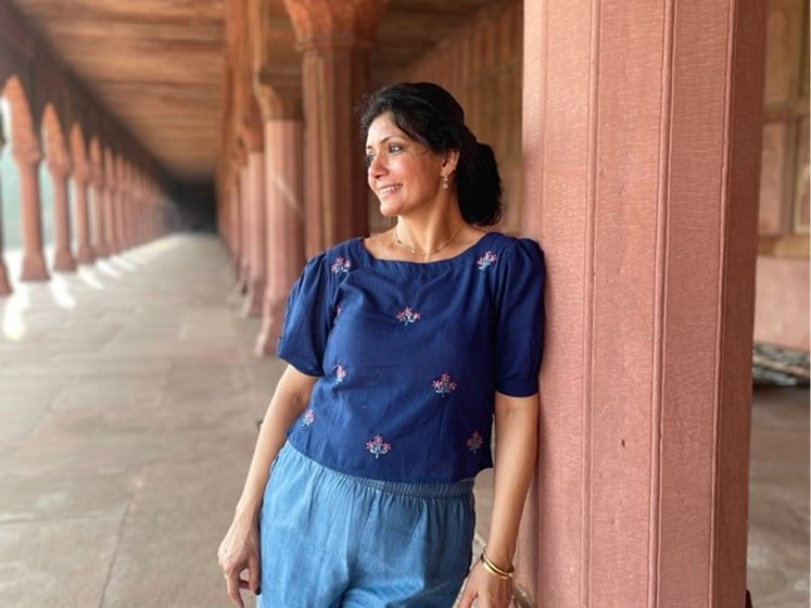 Vandita Parikh leaning against a pillar at an iconic monument location in India.